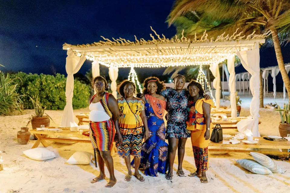 Betty and friends at night under a lit beach pavilion