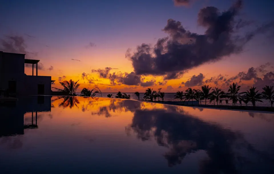 Sunset reflected in the infinity pool at The Beach Palace