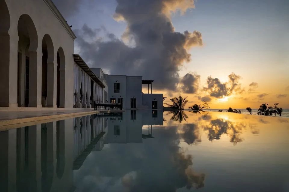 White arches reflected in the pool at sunrise